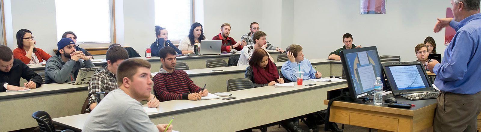 Business students sitting in classroom while progessor lectures